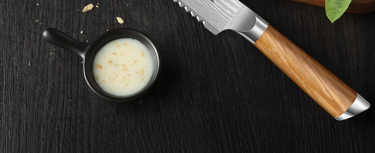 Détail manche brun bois d'olivier couteau à pain Hoshanho avec bol de sauce