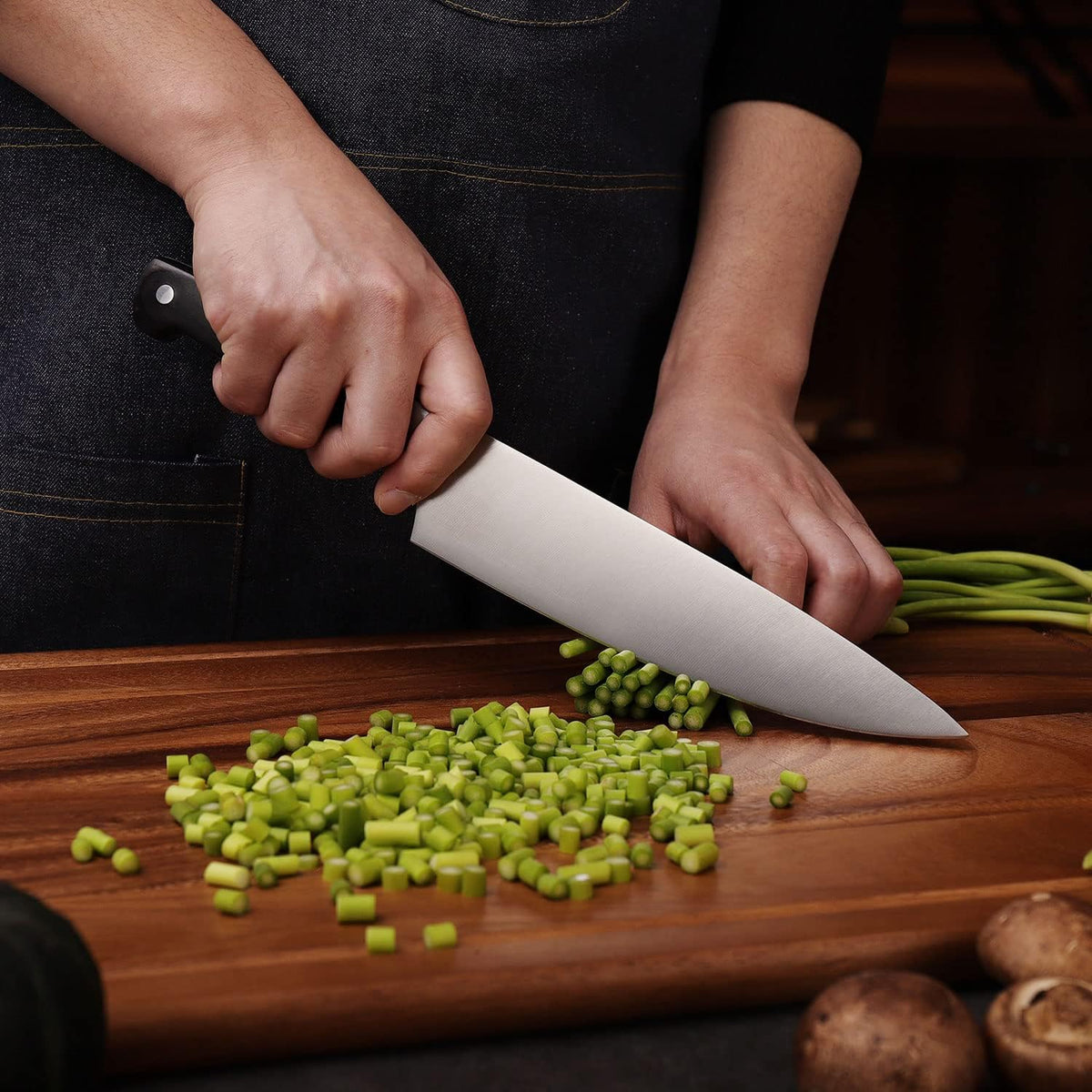 Couteau de chef Keemake en acier inoxydable coupant des légumes verts sur planche en bois