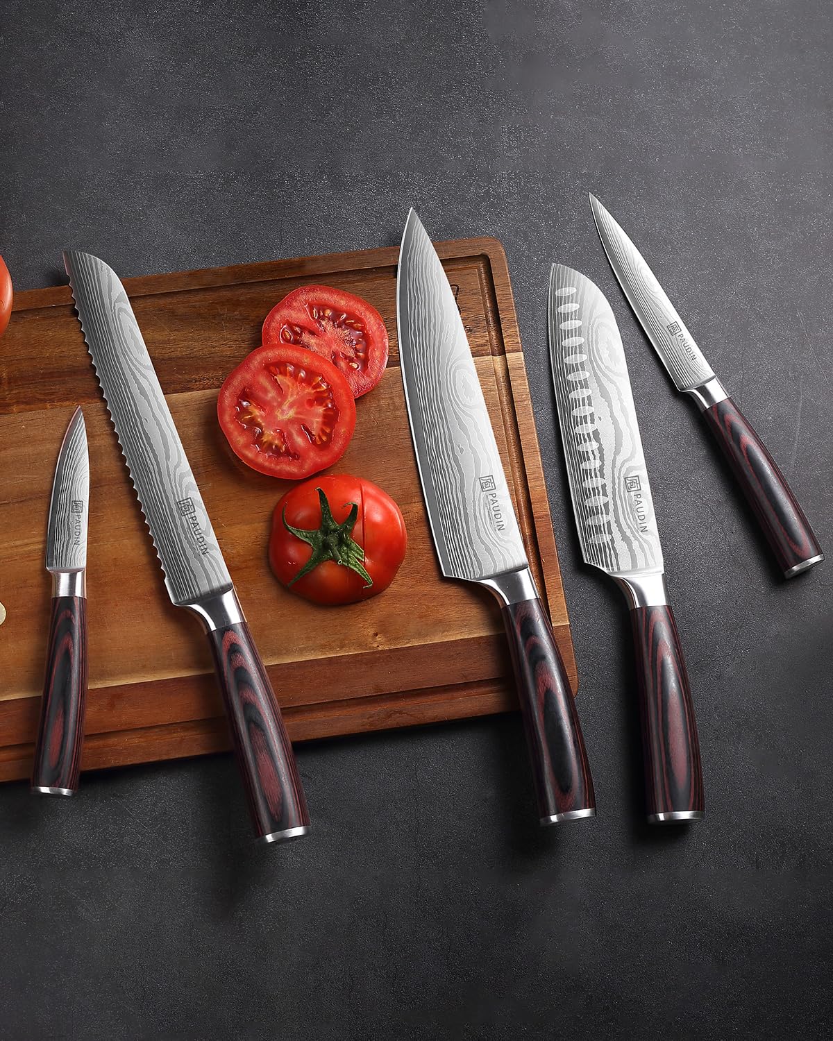 Set 5 couteaux Paudin lame Damascus manche pakkawood rouge sur planche bois avec tomates